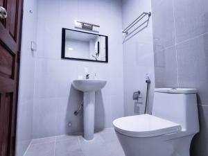 马累Reef Guest House的白色的浴室设有卫生间和水槽。