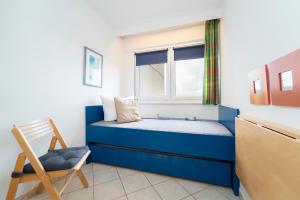 达默Berolina Wohnung 706的一间小卧室,配有蓝色的床和椅子