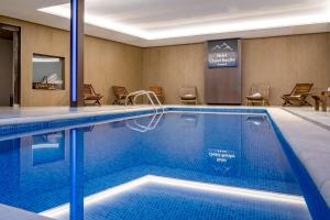 巴奎伊拉-贝莱特Hotel Chalet Bassibe的游泳池位于酒店客房内,配有椅子和桌子