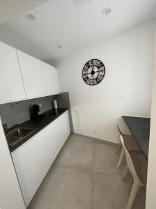 斯图加特S-AP Daily Room Stuttgart的厨房配有水槽和墙上的时钟