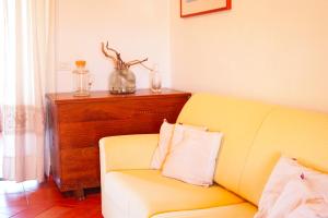 维拉西米乌斯Mereu Central Apartment的客厅配有黄色的沙发和桌子