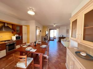 维拉西米乌斯Mereu Central Apartment的厨房以及带木桌和椅子的客厅。