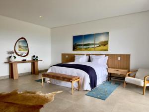 安帕鲁Lake Vilas Charm Hotel的一间卧室配有一张大床和一把椅子