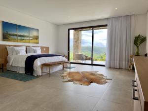 安帕鲁Lake Vilas Charm Hotel的一间卧室设有一张床和一个大窗户