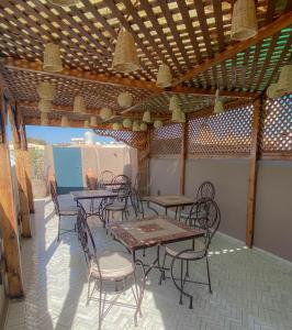 马拉喀什Riad Dar Marrakcha的木制天花板下设有带桌椅的天井。