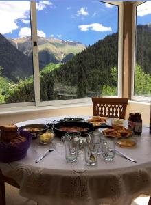 MackaHamsiköy Dağ Evi的一张桌子,配有食物和玻璃杯,享有山景