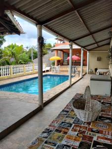 迈林克Chácara Santo Expedito - Mairinque-SP的庭院设有游泳池、桌子和地毯。