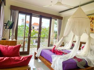 乌布梅哈亚撒2号旅馆的一间卧室配有两张带窗帘的床和一个阳台