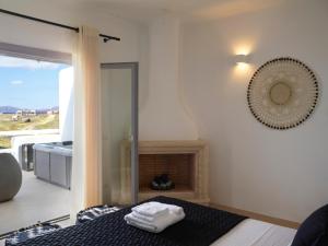 阿克罗蒂里Absolute Paradise Santorini的一间卧室设有一张带壁炉和窗户的床。
