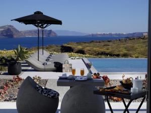 阿克罗蒂里Absolute Paradise Santorini的一张桌子,上面放着一个食物托盘和一把雨伞