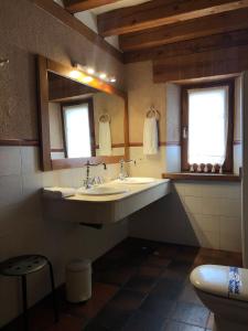 纳瓦夫里亚Posada Real Mingaseda的一间带水槽和两面镜子的浴室以及一间卫生间