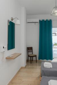卡马利奥斯卡酒店的一间设有蓝色淋浴帘和椅子的客房