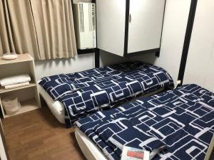 京都KYOTO Guest House的一间卧室配有一张带蓝色和白色棉被的床