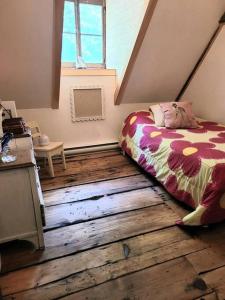 Saint-JeanOm chalet 1 avec spa face au fleuve的一间卧室配有一张床,铺有木地板