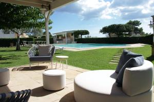 帕图Hotel Montecallini - Adult Only 14的一个带沙发和椅子的庭院和一个游泳池