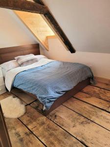 Saint-JeanOm chalet 1 avec spa face au fleuve的一间卧室配有一张铺有木地板的床。