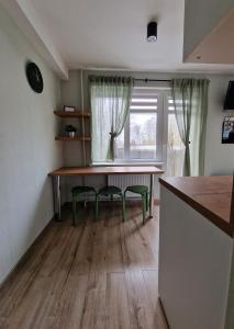 叶卡布皮尔斯Apartamenti Jēkabpilī的厨房配有桌子和两把椅子,设有窗户。