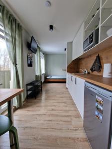 叶卡布皮尔斯Apartamenti Jēkabpilī的厨房铺有木地板,配有白色橱柜。