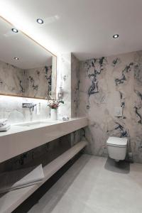 杜布罗夫尼克City Hotel Dubrovnik的一间带水槽、卫生间和镜子的浴室