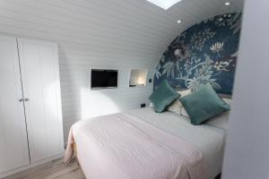 滕比The Lodge @Quarrywood的一间卧室配有一张带花卉壁纸的大床