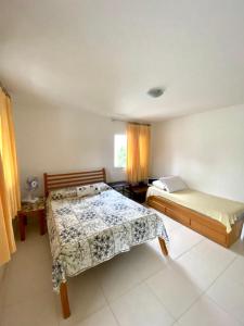 伊塔帕里卡岛维拉克鲁兹apartamento de frente para o mar的一间卧室设有两张床和窗户。