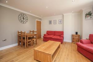 泰晤士河畔金斯顿Riverside 2 Bedroom Central Kingston Flat的客厅配有红色的沙发和桌子