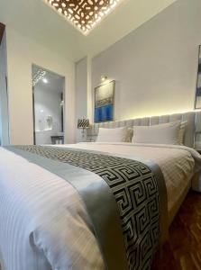 达卡Empyrean Dhaka City Centre的白色卧室配有一张带白色枕头的大床