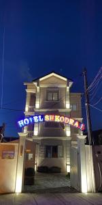 斯库台Hotel Shkodra L的前面有 ⁇ 虹灯标志的房子