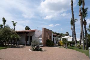 加利波利Villetta Del Salento Exclusive B&B的棕榈树房屋和砖车道