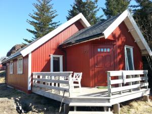卡伯尔沃格Sandvika Camping的前面设有两把椅子的红色小屋