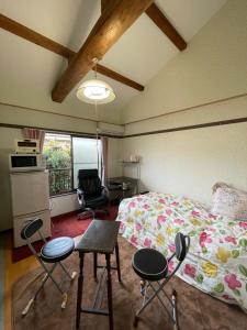 KinugasaKyoto Wakouan Retro Stay的一间卧室配有一张床、两把椅子和一张桌子