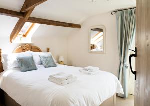 克里克豪厄尔Neuadd B&B Suites的卧室配有白色床和毛巾