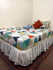 公主港Balai Vivencio Hostel的一张大床,上面有五颜六色的毯子