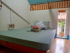 公主港Balai Vivencio Hostel的一间卧室,床上放着一篮鲜花