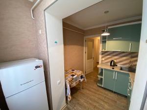 第比利斯APARTMENT in TBILISI Koko的厨房配有绿色橱柜和白色冰箱