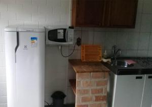 博西坎加Vila da Praia的厨房配有微波炉、水槽和冰箱