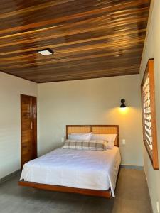伊卡普伊Lyttos Bungalows的一间卧室设有一张木天花板床。