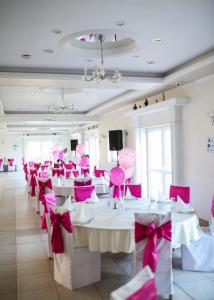 KnićHotel Ravni Gaj的用餐室配有粉红色的桌椅和弓形