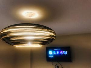 科尔多瓦NUEVOCENTRO 1的天花板上挂着一个大吊灯,配有电视