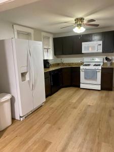 芝加哥Lincoln Park Aparment with Backyard!的厨房铺有木地板,配有白色冰箱。