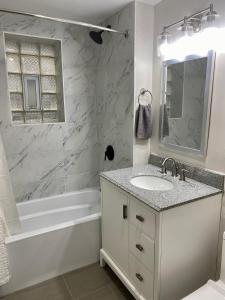 芝加哥Lincoln Park Aparment with Backyard!的白色的浴室设有水槽、浴缸和镜子