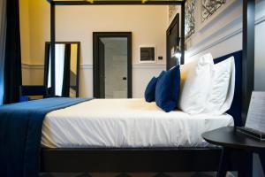 罗马罗马奢华酒店的一间卧室配有一张带蓝色和白色枕头的床