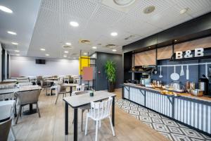 阿斯克新城B&B HOTEL Lille Grand Stade的一间带桌椅的餐厅和一间厨房