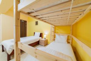 菲尔福尔德La Hacienda的黄色墙壁的客房内设有两张双层床。