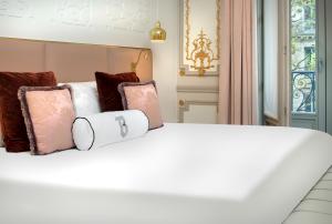 巴黎鲍曼酒店的一张白色的床,上面有枕头