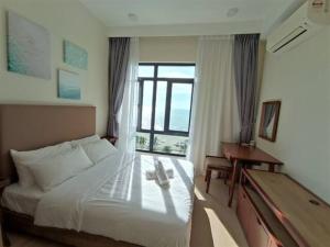 关丹Timurbay Seafront Residences by Nature Home的酒店客房带一张床和一架钢琴