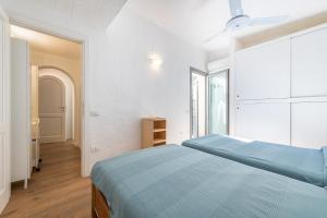 NotteriDOMUS MARIS Villa Charmant Porto Giunco Notteri VILLASIMIUS的一间白色客房内的蓝色床卧室