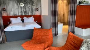 魏勒格Orange Lounge的一间卧室配有一张床和两张橙色椅子