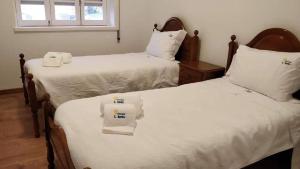 卡米尼亚Albergue de São Bento的配有白色床单的客房内的两张床