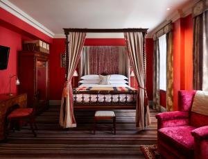 伦敦The Zetter Clerkenwell的一间卧室设有红色的墙壁和一张带天蓬的床